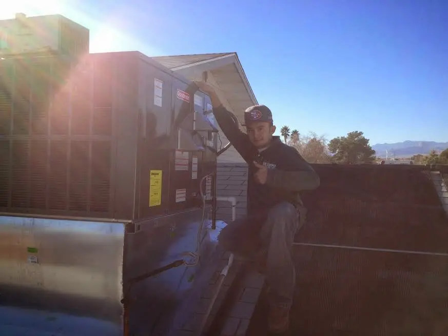HVAC technician performing AC Tune-Up on a rooftop unit in Frankenmuth